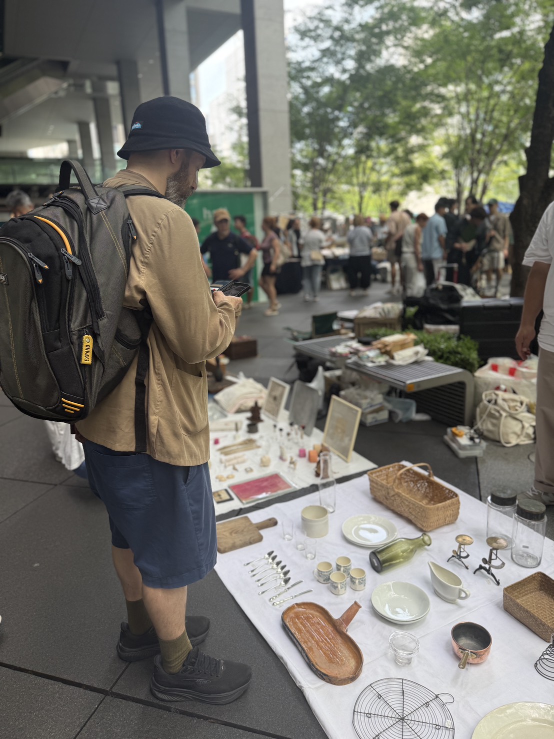 Browsing an outdoor flea market stall of antiques and homeware in Tokyo